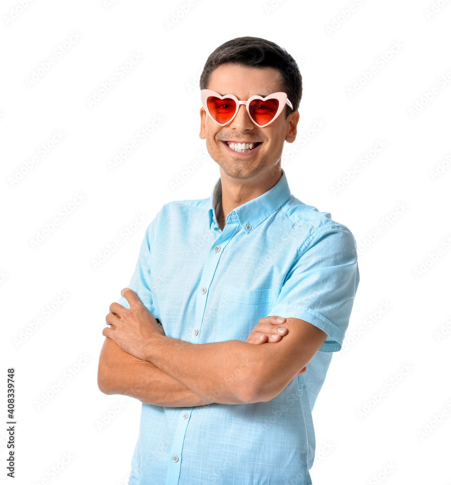 Handsome man wearing heart-shaped glasses on white background