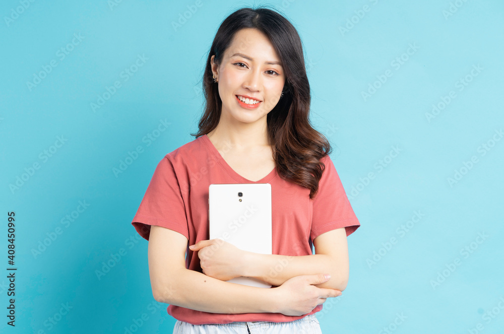 Beautiful Asian woman smiling holding tablet computer