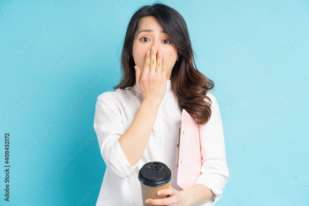 Beautiful Asian businesswoman holding a paper coffee cup in her hand, she covered her mouth with her