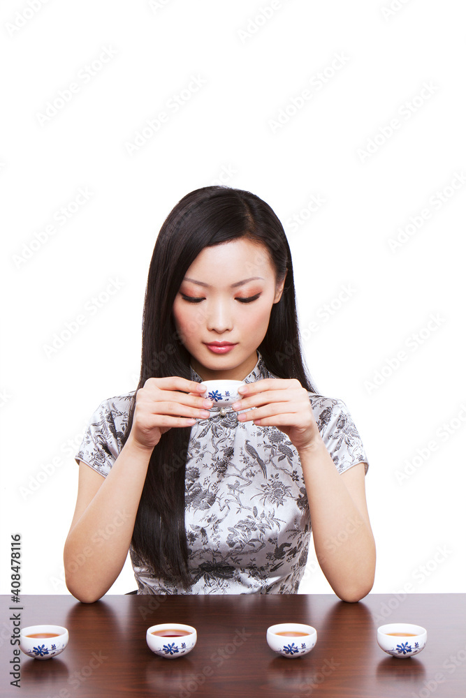 Wear cheongsam Oriental young woman in preparation for the tea ceremony