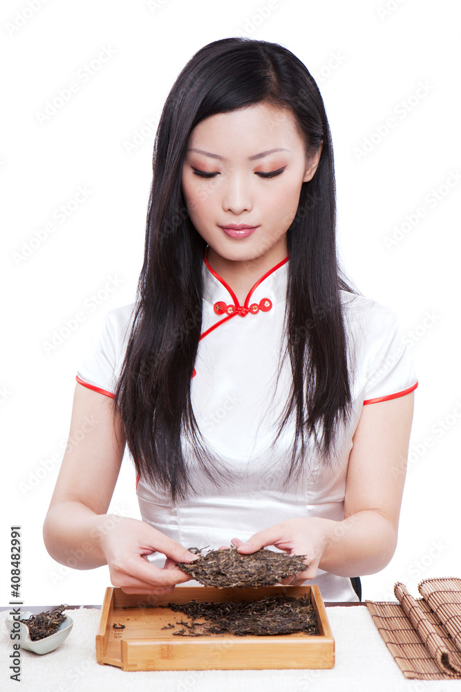 Wear cheongsam Oriental young female holding a Puer brick tea