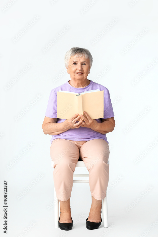 Senior woman reading book on white background