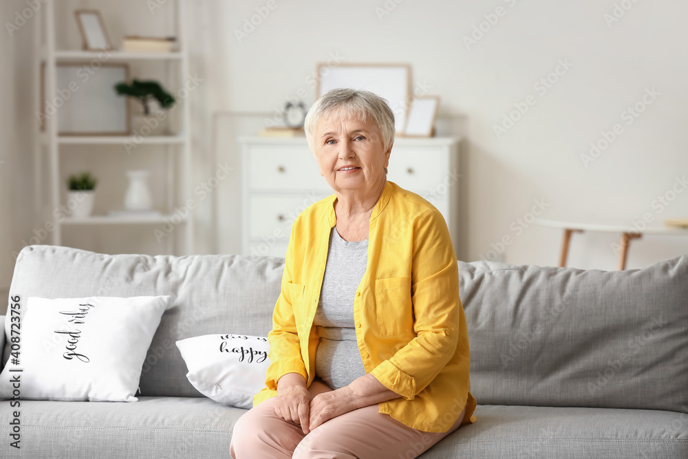 Senior woman sitting on sofa at home