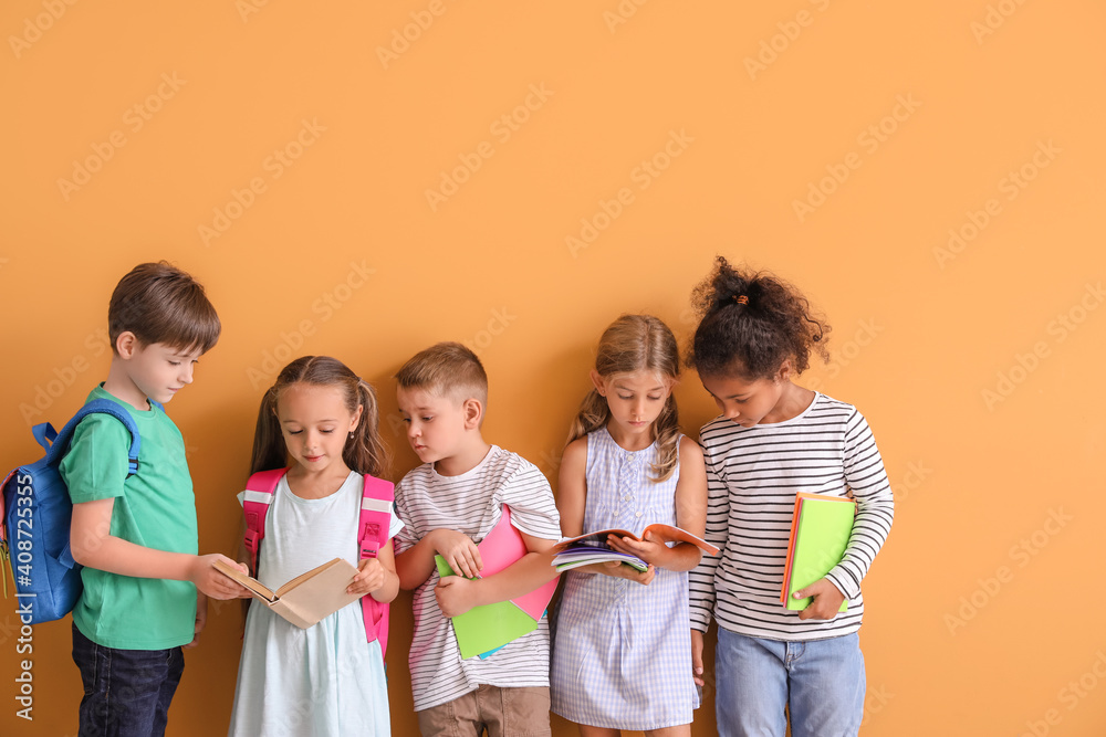 Little children with books on color background