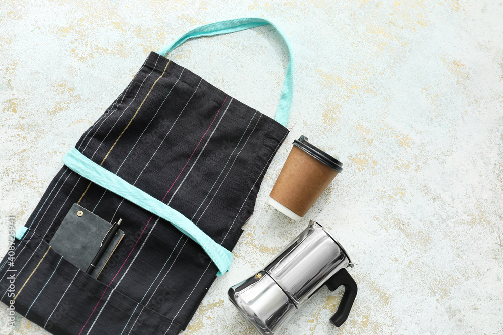 Apron, paper cup and cezve on light background