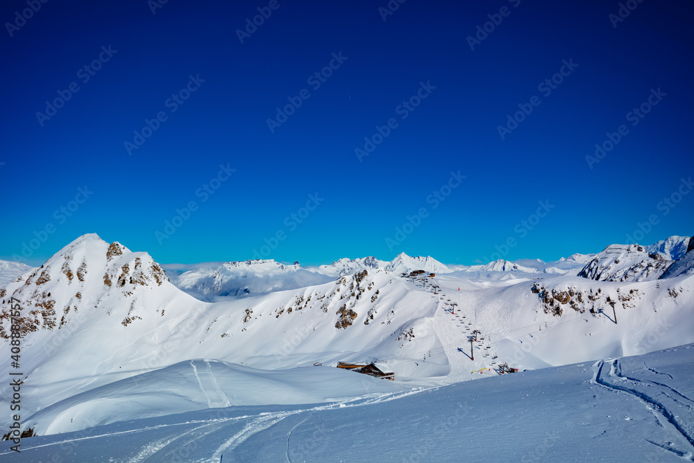 高山、滑雪缆车站、法国阿尔卑斯山顶的全景和云朵被雪覆盖