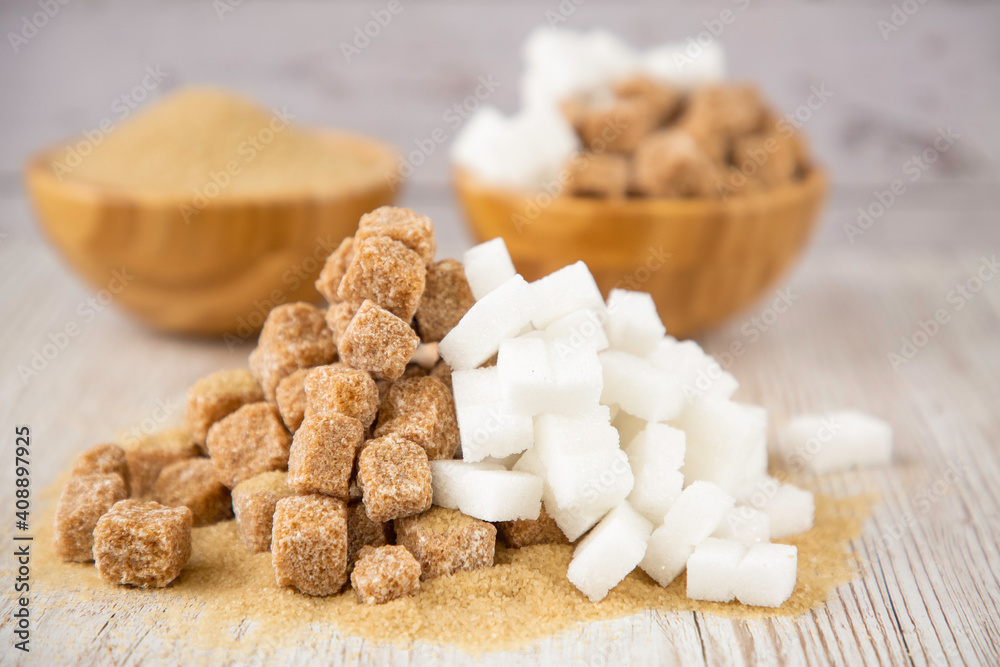 Bowl wood and and white and Brown sand sugar and lump sugar on dark background