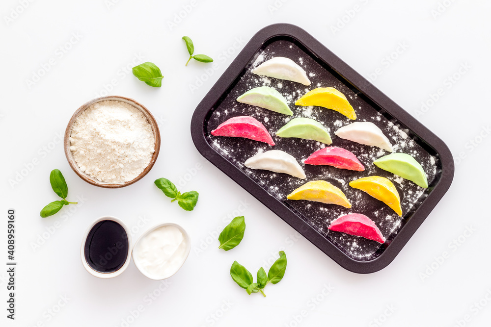 Colorful dumplings tortellini on baking sheet, top view