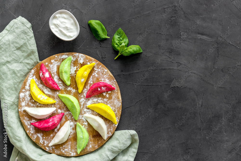 Chinese colorful raw dumplings or ravioli on cutting board, top view