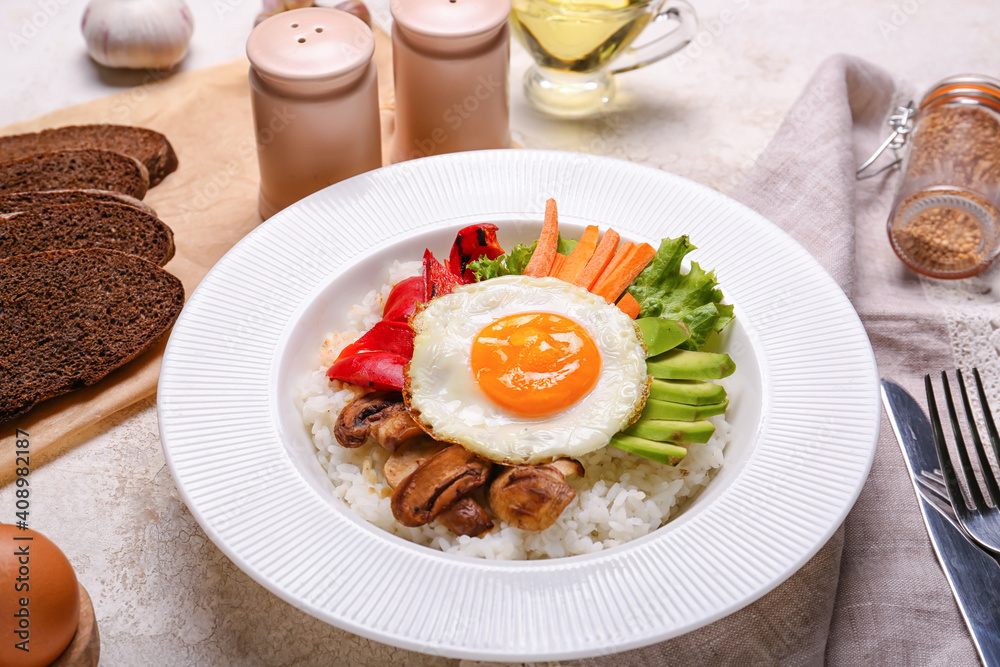 Plate with tasty egg, vegetables and rice on table