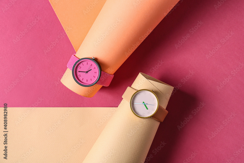 Stylish wrist watches on colorful background