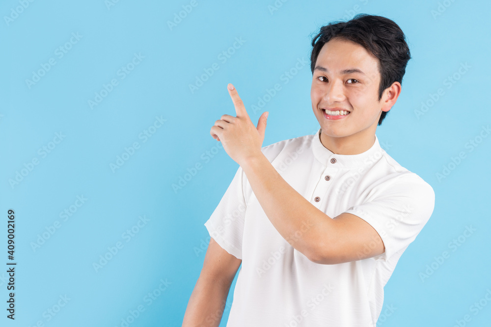 The young man standing on his side pointed his hand to the side with a cheerful expression