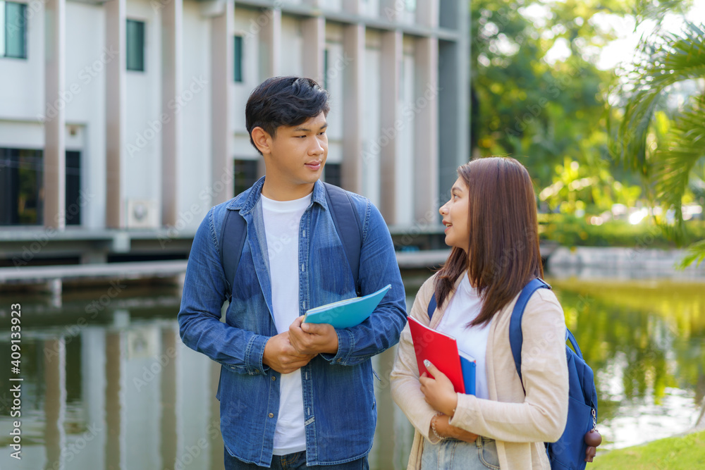 两对亚洲情侣大学生在阳光明媚的da人行道上散步聊天