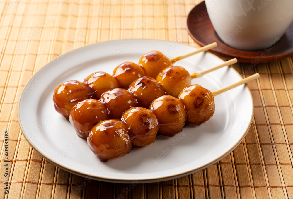 Mitarashi dango and green tea on a wooden background