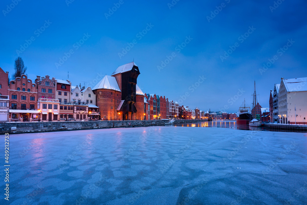 Medieval port crane in Gdansk at Motlawa river in snowy winter, Poland