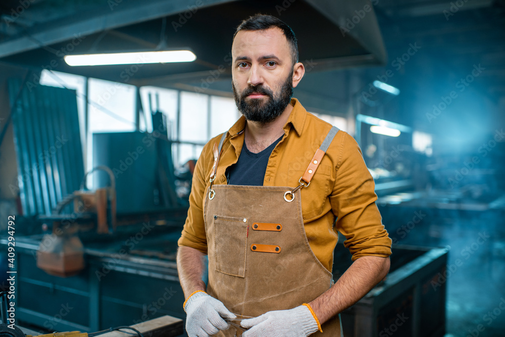 Metal industry worker at factory look at camera