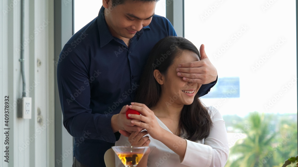 Romantic couple giving gift to lover at restaurant . Happy couple lifestyle .