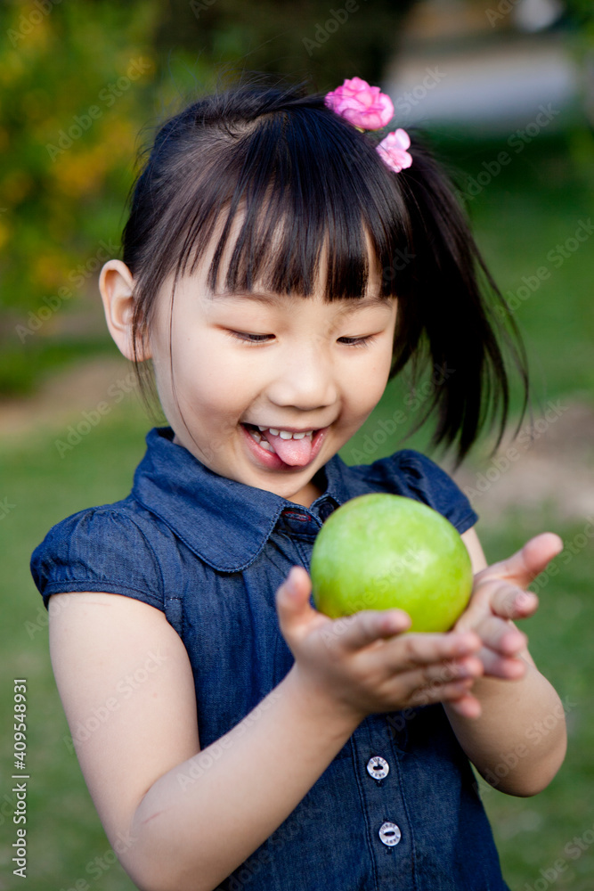 Girls holding an apple in her hands