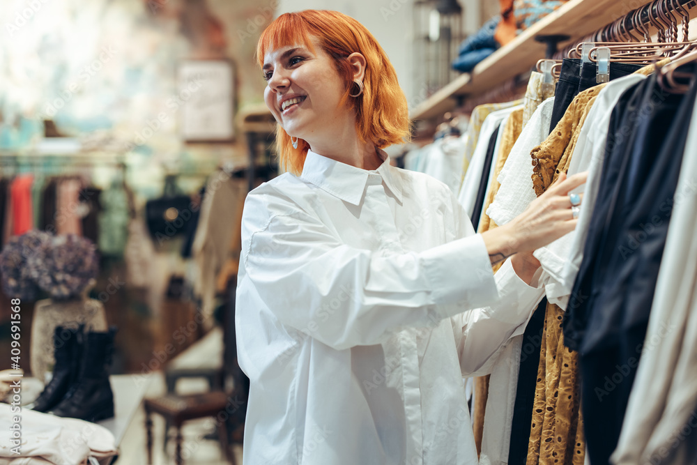 有魅力的女人在店里挑选衣服