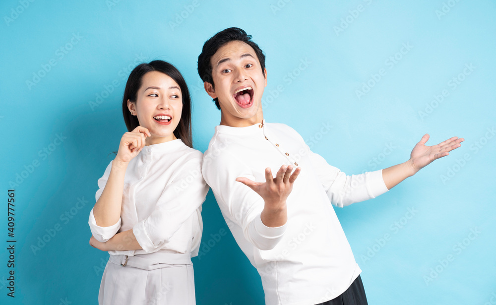 Portrait of young couple standing posing on blue background