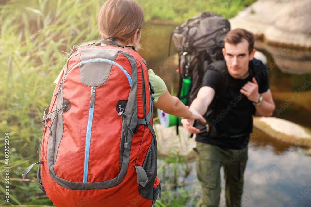 Couple of young tourists near river in countryside