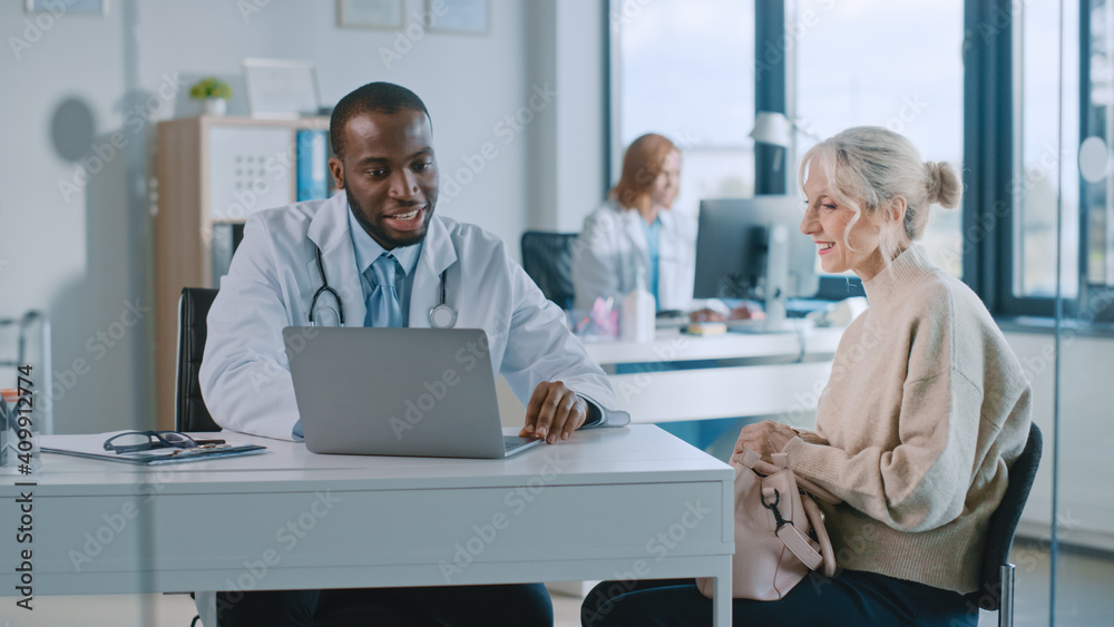 Family Doctor is Reading Medical History of Senior Female Patient and Speaking with Her During Consu