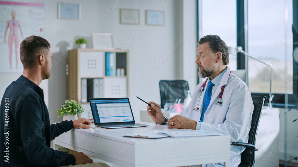 Friendly Family Medical Doctor is Explaining Diagnosis to a Young Male Patient and Showing Medical T