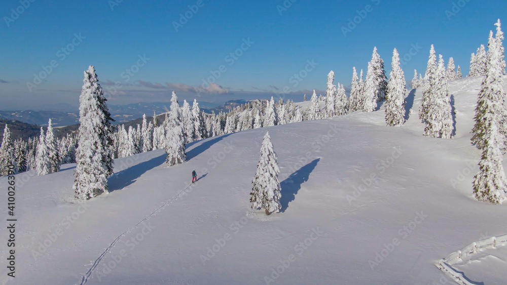 航空航天：滑雪旅游者周围冬季景观的壮观飞行镜头。