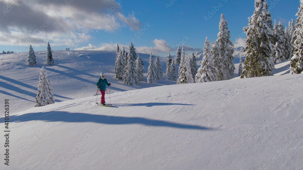 空中飞行：在斯洛文尼亚Velika Planina，围绕一名女性游客滑雪旅行飞行。