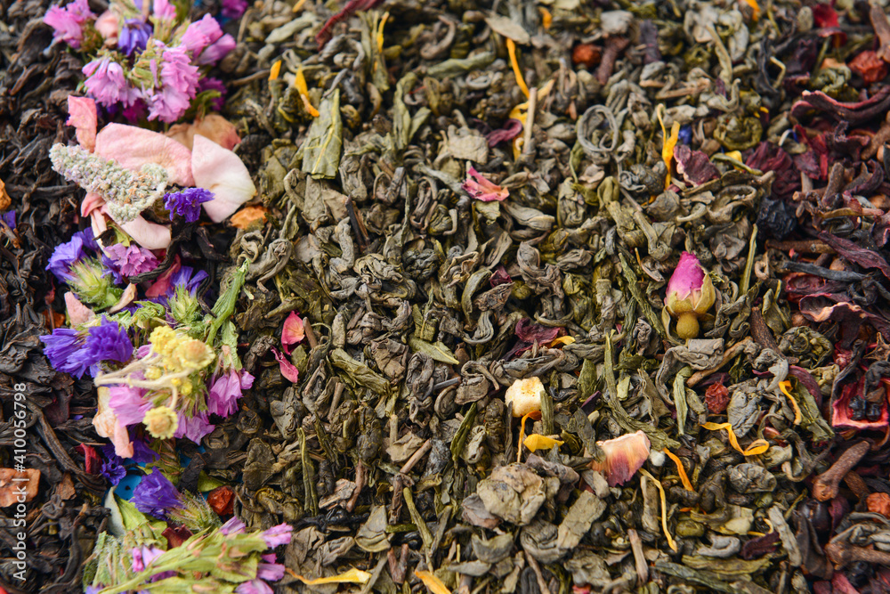 Dry tea leaves and flowers as background