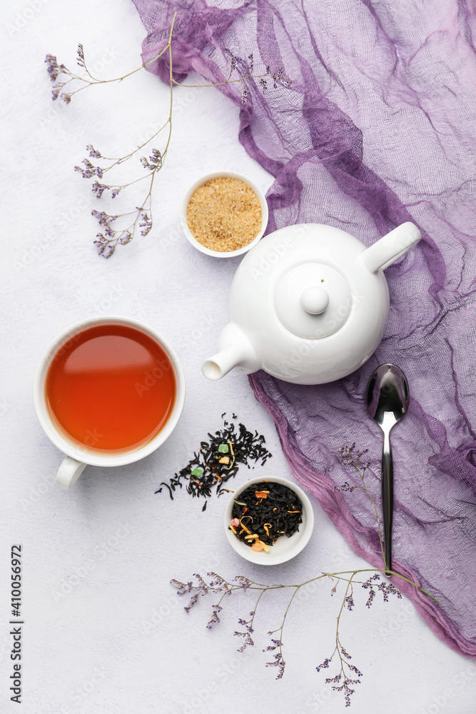 Composition with teapot and cup of tea on light background