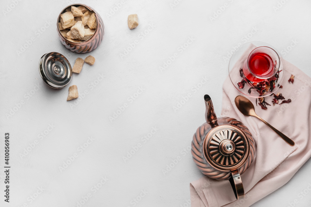 Composition with teapot and glass of tea on light background