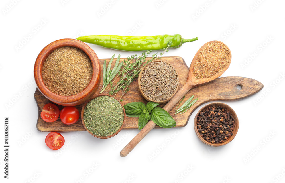 Board with different spices and herbs on white background