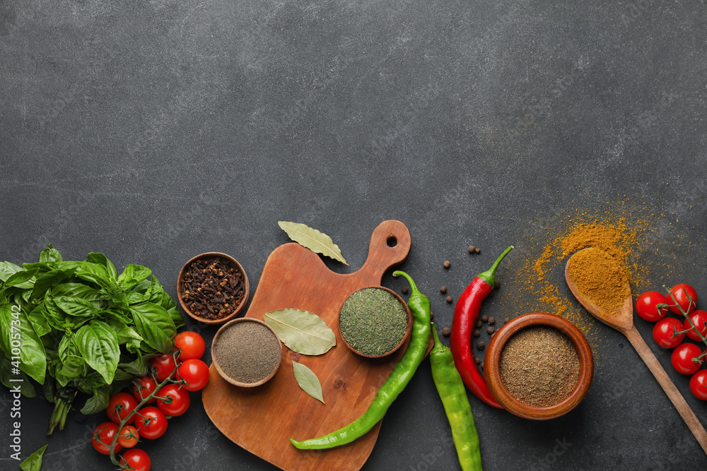 Composition with different spices and herbs on dark background