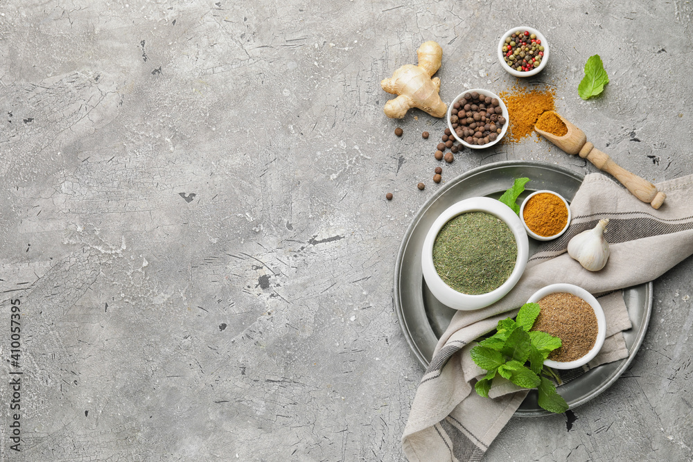 Composition with different spices and herbs on grey background