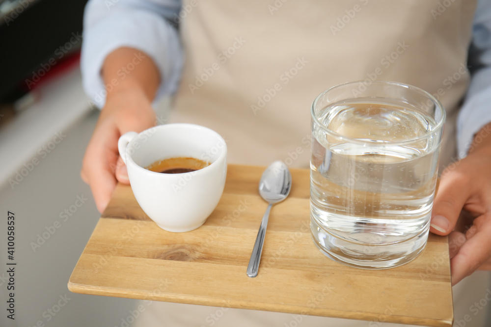 年轻的咖啡师在咖啡馆里喝着热意式浓缩咖啡，特写