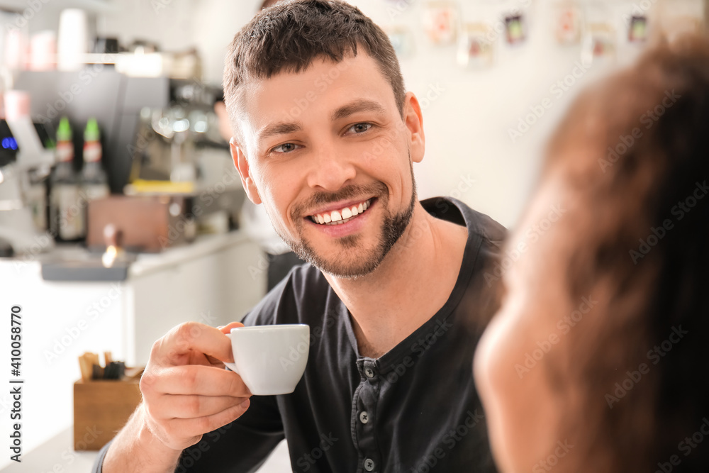 Happy man drinking hot espresso in cafe