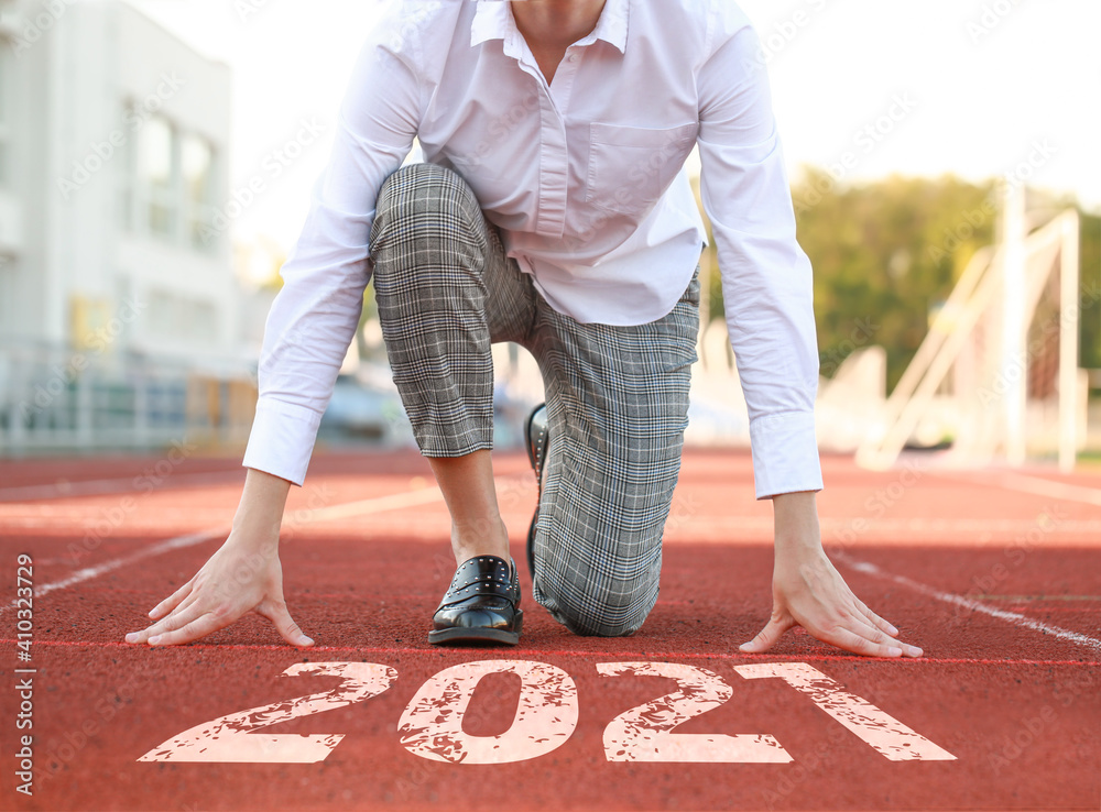 Young businesswoman in crouch start position at the stadium  Concept of goal achievement