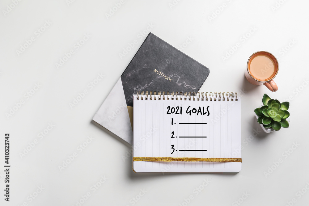 Notebooks with empty to do list for 2021 and cup of coffee on light background