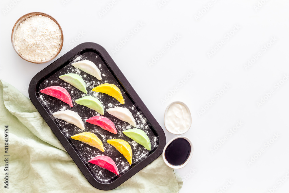 Top view of colorful raw dumplings on baking sheet