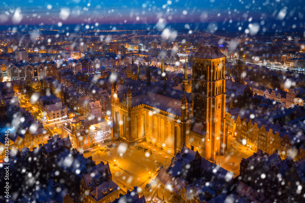 Aerial view of the old town in Gdansk with St. Mary Basilica at snowy night, Poland