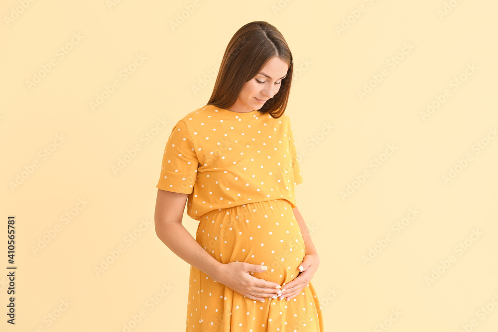 Beautiful pregnant woman on color background