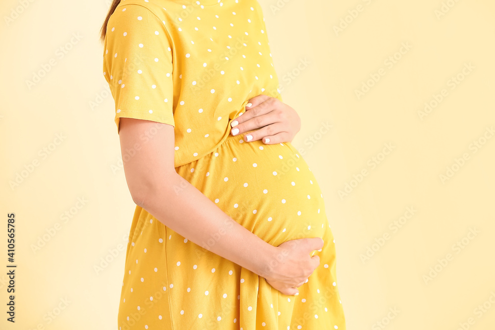 Beautiful pregnant woman on color background