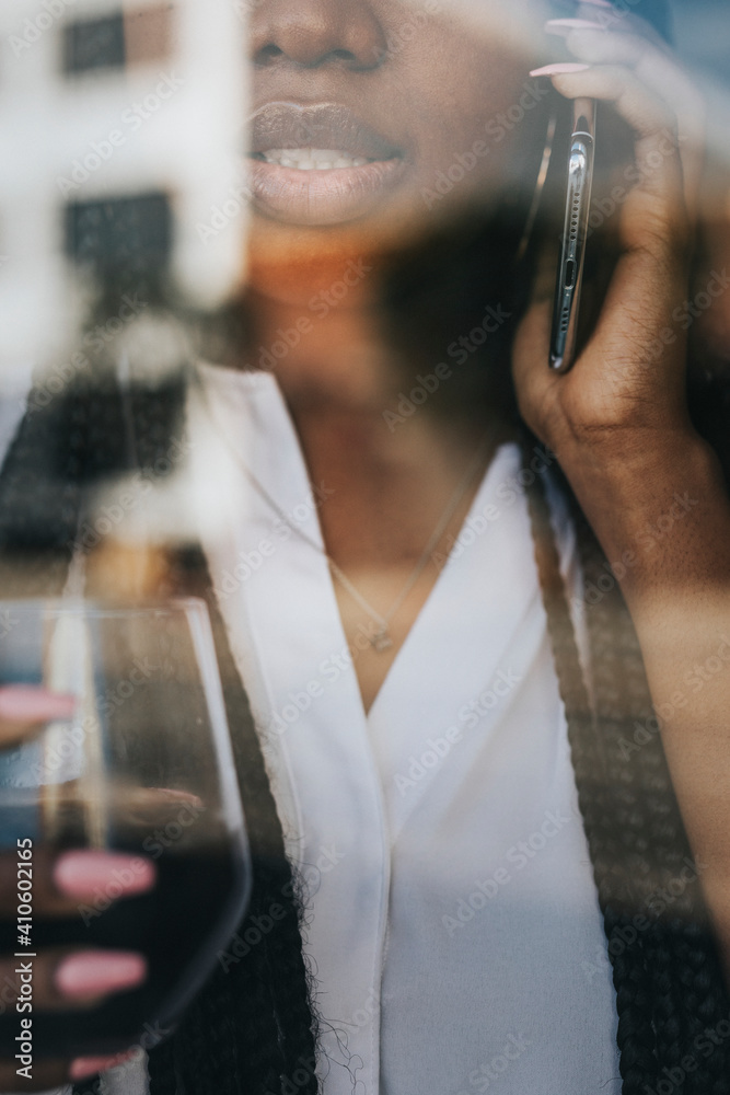 Black woman on the phone looking out the window