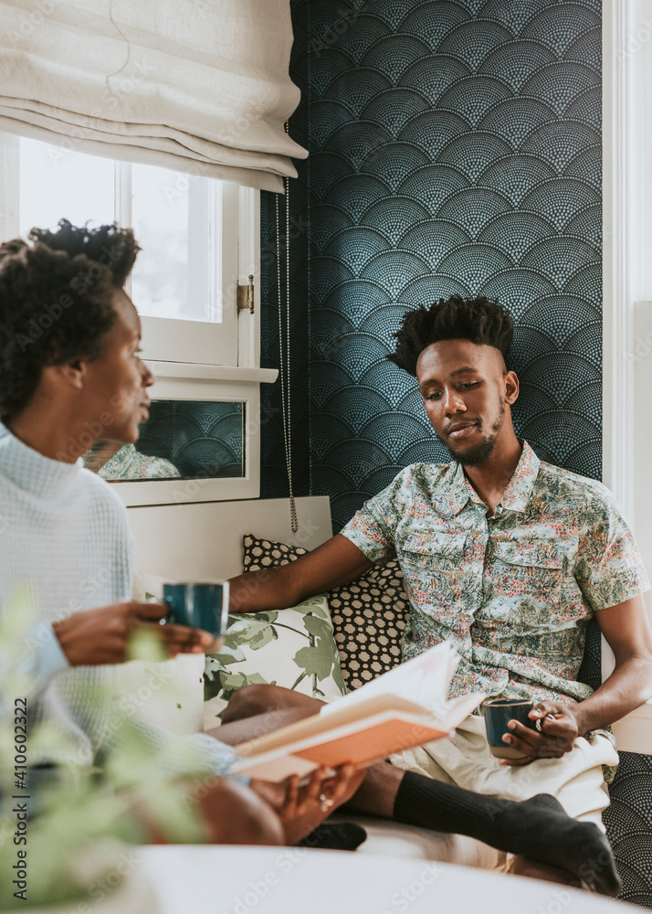 Happy black couple reading a book at home