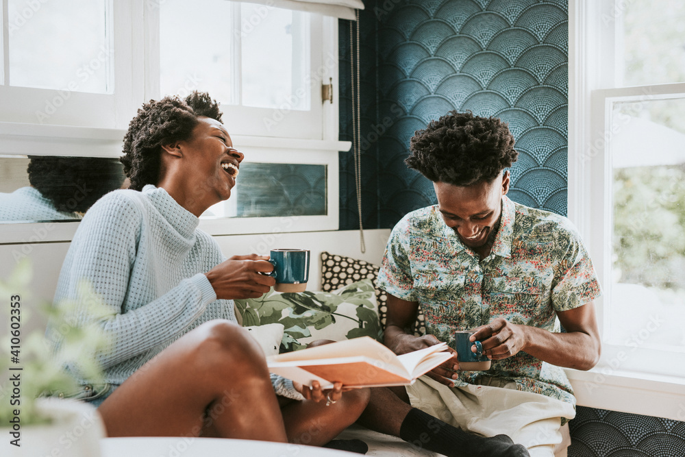 Happy black couple reading a book at home