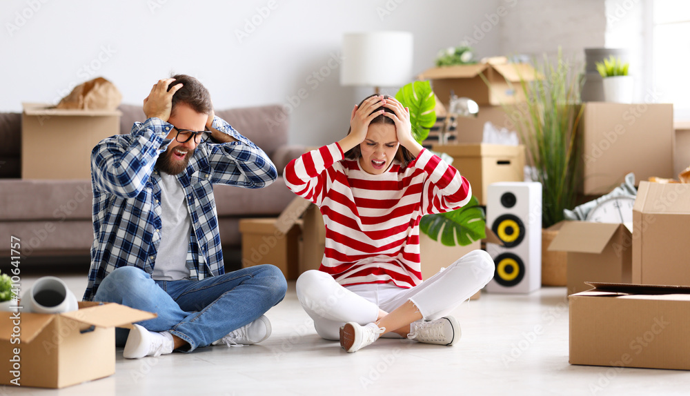 Stressed couple in new apartment with packed stuff