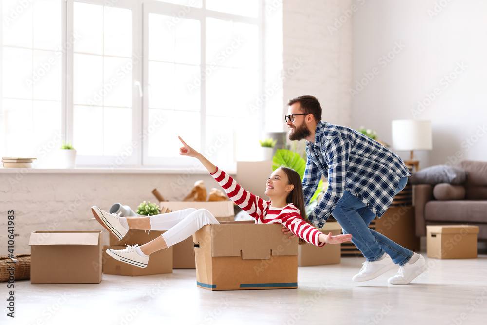 Cheerful couple having fun in new apartment