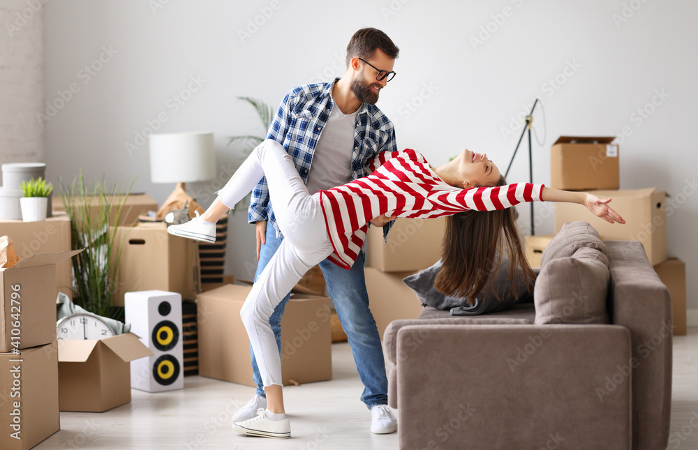 Joyful couple dancing in new apartment