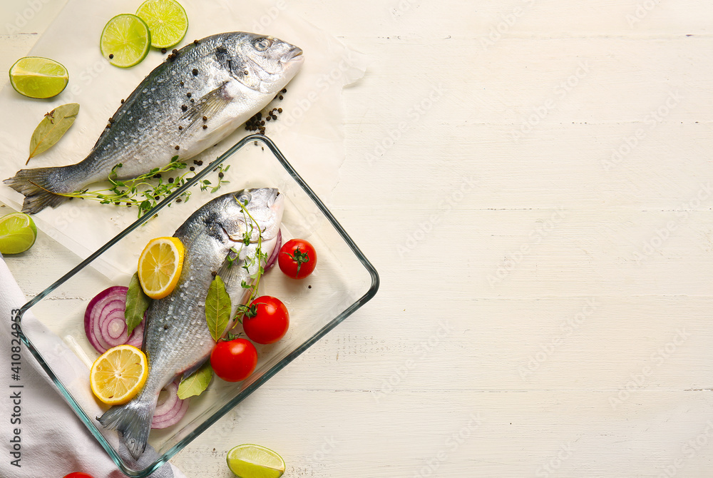 Raw dorado fish with ingredients on light background